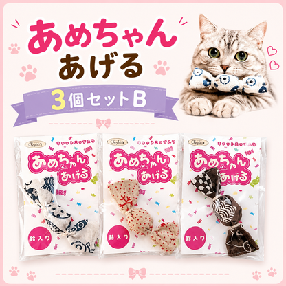 「あめちゃんあげる」のメインカット。飴玉そっくりの布製猫用おもちゃを咥える猫と、和柄6種類の個包装・単品を並べた写真。選べる6種類の表記あり