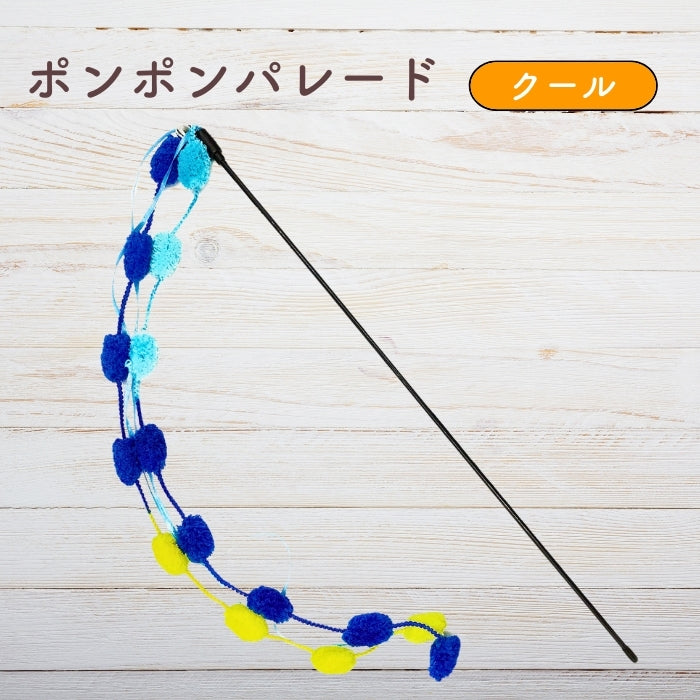木目調の背景に置かれたクールカラーのポンポンパレード。水色・青・黄色のポンポンが連なるじゃらい全体像