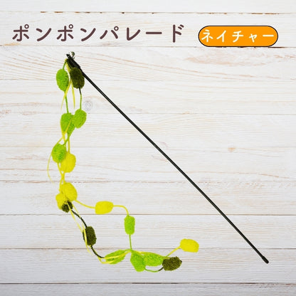 木目調の背景に置かれたネイチャーカラーのポンポンパレード。緑・黄緑・黄色のポンポンが連なるじゃらい全体像