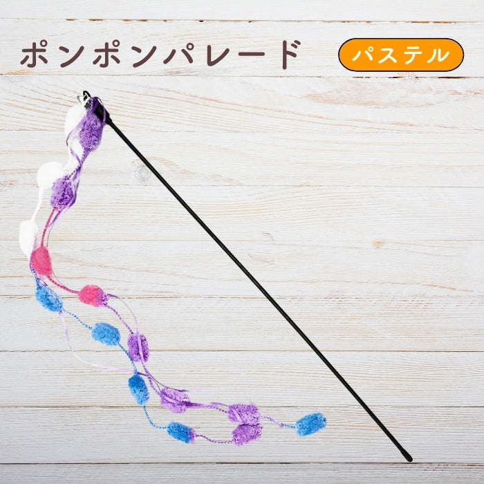 木目調の背景に置かれたパステルカラーのポンポンパレード。紫・ピンク・青のポンポンが連なるじゃらい全体像