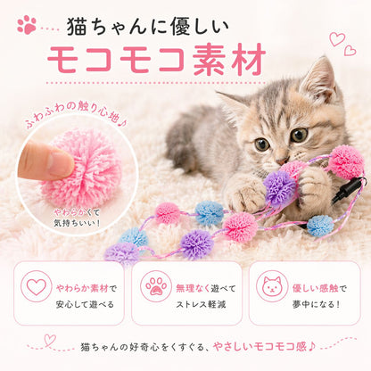 毛布の上でポンポンに前脚を乗せる子猫と、指でつまむポンポンの拡大写真。「猫ちゃんに優しいモコモコ素材」「やわらかくて気持ちいい！」の説明と、安心して遊べる・ストレス軽減・優しい感触の3特長を掲載