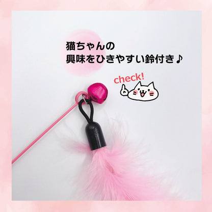 「猫ちゃんの興味をひきやすい鈴付き」の訴求。ピンクの羽パーツの付け根にある鈴と黒い持ち手部分のアップ