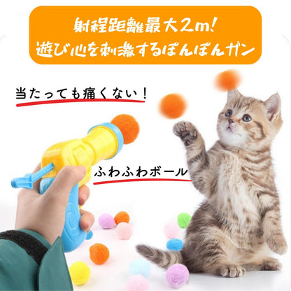 射程距離最大2m、当たっても痛くないと書かれた訴求カット。ガンからオレンジ色のふわふわボールが発射され、子猫が前足を伸ばして追う