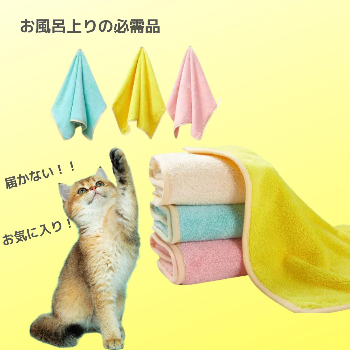 お風呂上がりの必需品という見出し。ブルー・イエロー・ピンクの小さめタオル3枚と、重ねて畳んだ厚手タオル、後ろ足で立ち上がってタオルに手を伸ばす猫