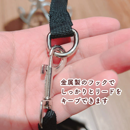 手のひらに乗せた金属製の丸カンとナスカン(フック)の接写。「金属製のフックでしっかりとリードをキープできます」のコピー