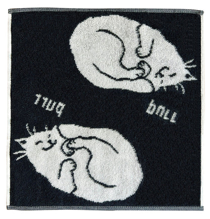 黒地に白猫が丸まって眠る柄のタオル。ローマ字が反転した「purr」「ball」の文字入り