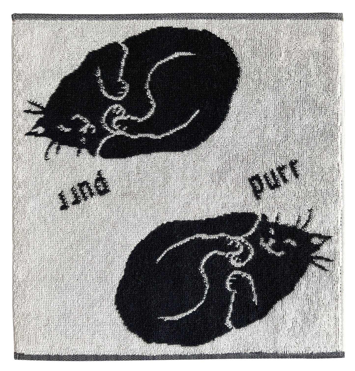 白地に黒猫が丸まって眠る柄のタオル。「purr」の文字入り