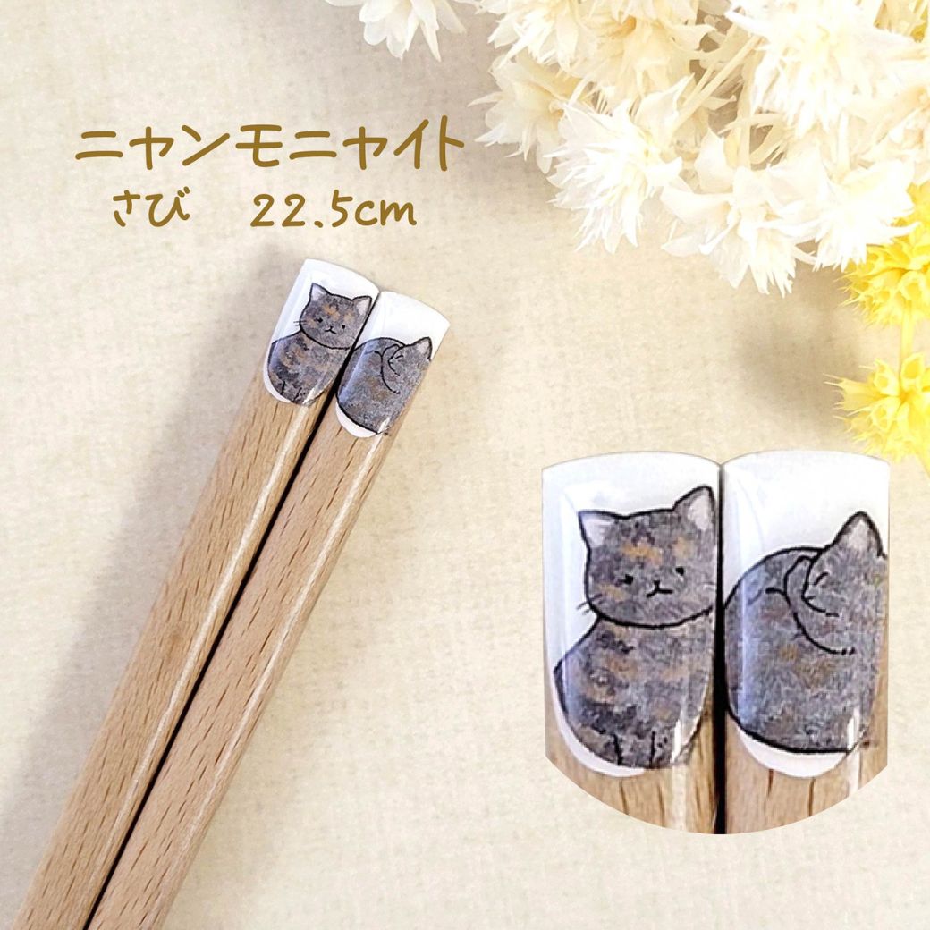 さび柄、22.5cmの表記。茶と黒が混じったさび猫の座り姿と丸まった姿を箸先に描いたデザインのアップと拡大カット