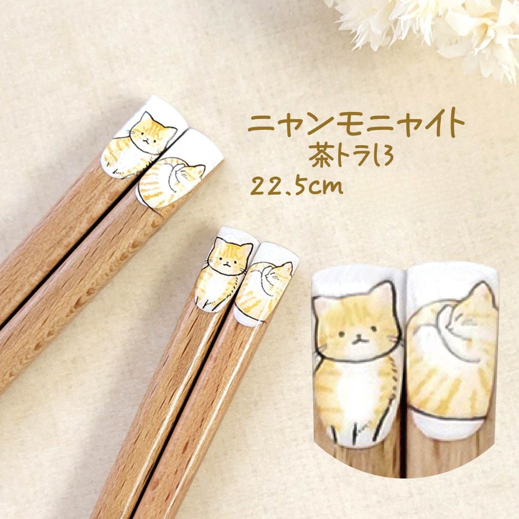 「毎日の食卓にかわいい猫をプラス!」の見出し。猫柄の持ち手を花のように円形に並べた天然木の箸12膳、選べる12種類・日本製の表記