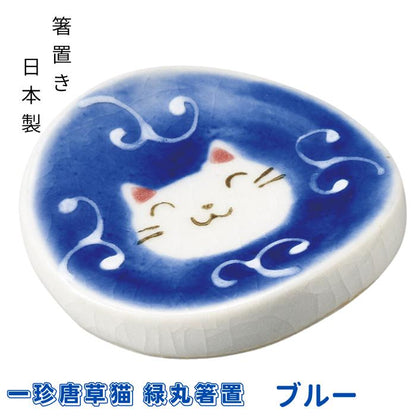ブルーの一珍唐草猫 緑丸箸置。深い青地に唐草模様と微笑む白猫の顔を描いた丸い陶器箸置き、箸置き・日本製の表記