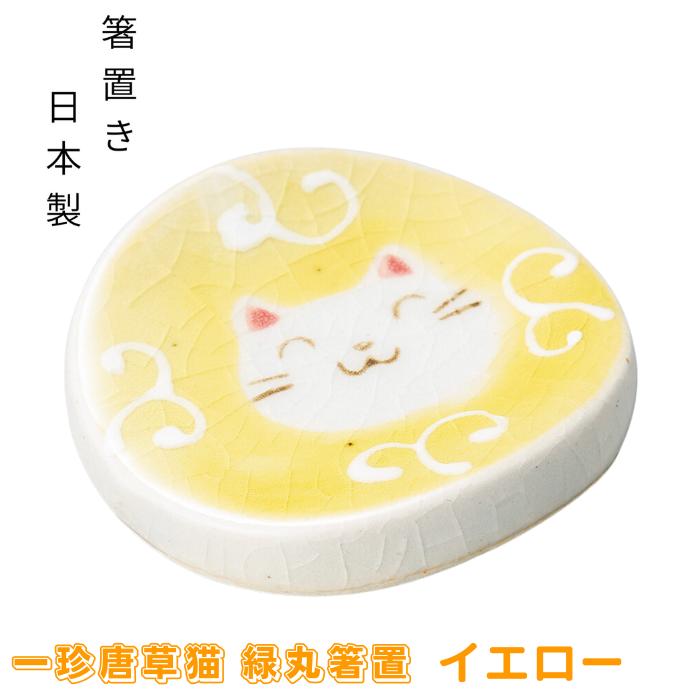 イエローの一珍唐草猫 緑丸箸置。黄色地に唐草模様と微笑む白猫の顔を描いた丸い陶器箸置き、箸置き・日本製の表記