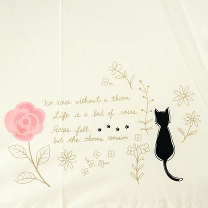 生成り地の傘に描かれたバラと黒猫のワンポイント刺繍柄。英文詩「No rose without a thorn. Life is a bed of roses. Roses fall, but the thorns remain.」が入る