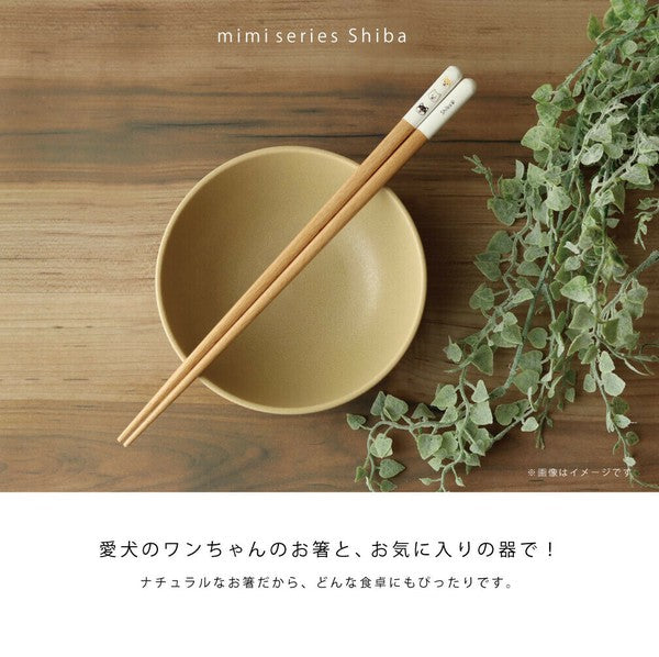 柴犬柄のmimi箸を黄色い器に渡した俯瞰カット。愛犬のお箸とお気に入りの器で、ナチュラルな箸だからどんな食卓にもぴったりとの訴求文