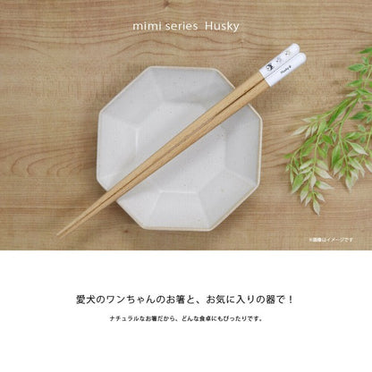 ハスキー柄のmimi箸を白い八角皿に渡した俯瞰カット。愛犬のお箸とお気に入りの器で、ナチュラルな箸だからどんな食卓にもぴったりとの訴求文