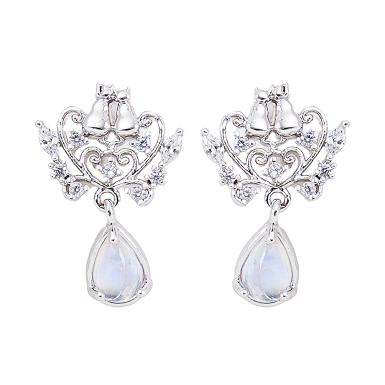 WING BLING正規代理店のロマンティックキャットピアス。2匹の猫と雫型の石をあしらったシルバーとローズゴールドのデザインを並べて紹介し、着用イメージでは「耳元に、ほんの少しのときめきを」と添える
