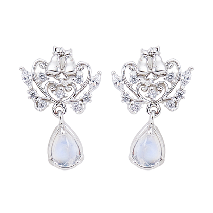 WING BLING正規代理店のロマンティックキャットピアス。2匹の猫と雫型の石をあしらったシルバーとローズゴールドのデザインを並べて紹介し、着用イメージでは「耳元に、ほんの少しのときめきを」と添える