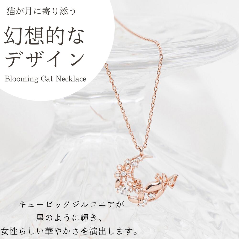 「猫が月に寄り添う幻想的なデザイン Blooming Cat Necklace」の紹介カット。ローズゴールドの三日月に花とキュービックジルコニアをあしらったペンダントを吊るして撮影