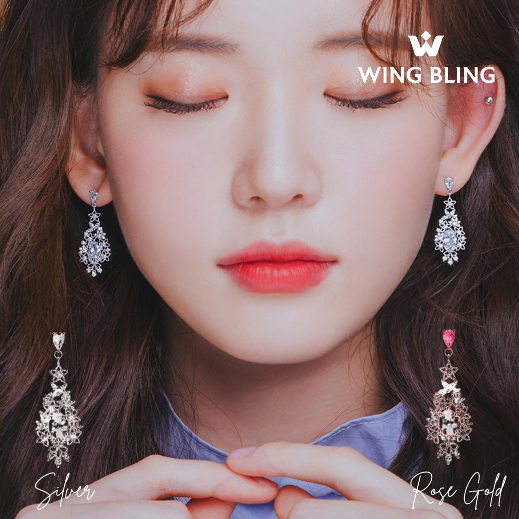 目を閉じたモデルが両耳でSilverとRose Goldを着け比べたカット。WING BLINGロゴと単体商品写真も並ぶ