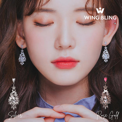 目を閉じたモデルが両耳でSilverとRose Goldを着け比べたカット。WING BLINGロゴと単体商品写真も並ぶ