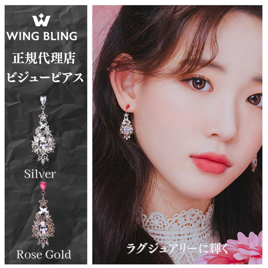 「ロマンティックドリーム ピアス」のカバー画像。WING BLING正規代理店・ビジューピアスの文字とシルバー/ローズゴールドのモチーフ見本、赤い石が耳元で輝くモデルの横顔
