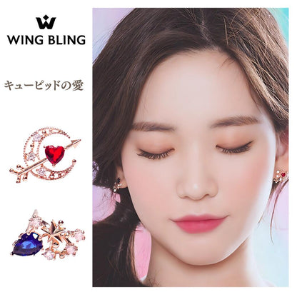 WING BLING「キューピッドの愛」商品トップ画像。左に赤いハートと三日月＆矢モチーフ、青い雫石と星モチーフのイヤリング2種、右に目を閉じて耳元を見せるモデル