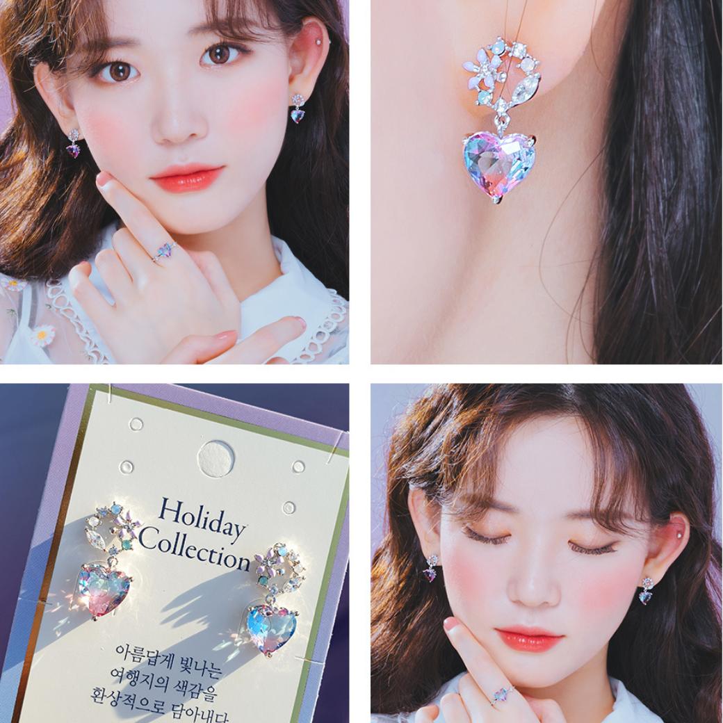 着用イメージ4カットのコラージュ。頬に手を添える正面カット、鎖骨付近のアップ、Holiday Collectionタグ付き商品カット、目を伏せた横顔カットでブルー系グラデーションハートピアスを紹介