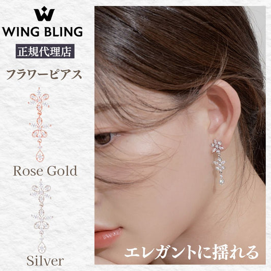 WING BLING正規代理店の花が咲く日ピアス紹介。花モチーフが連なるロング形状で、上からローズゴールドとシルバーの2色展開。大きな写真は着用イメージで頬にかかる髪と耳元に揺れるピアス、「エレガントに揺れる」のコピー