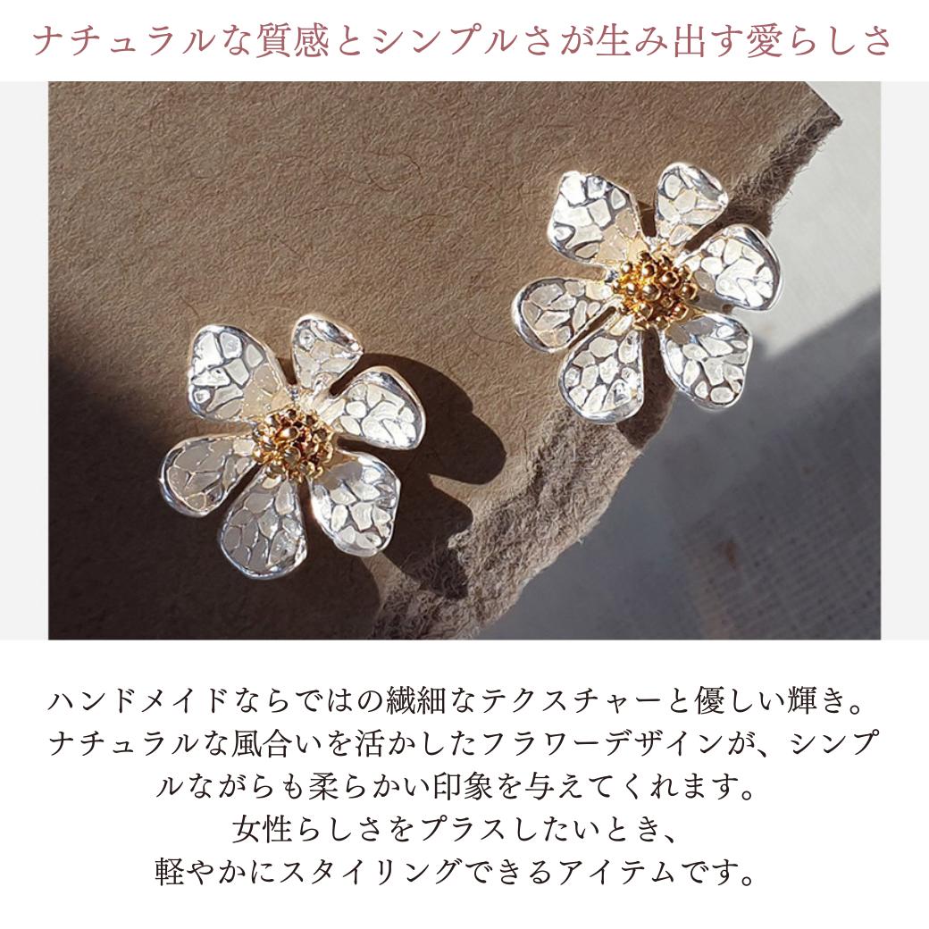 「ナチュラルな質感とシンプルさが生み出す愛らしさ」の見出しと光の中の花形イヤリング2個の写真。ハンドメイドならではの繊細なテクスチャーとナチュラルなフラワーデザインで柔らかい印象を与えると説明
