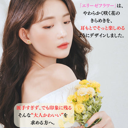 花束を持つモデルの耳元にピアスを装着。「やわらかく咲く花のきらめきを、耳もとでそっと楽しめるようにデザイン」「派手すぎず、でも印象に残る大人かわいいを求める方へ」の説明文