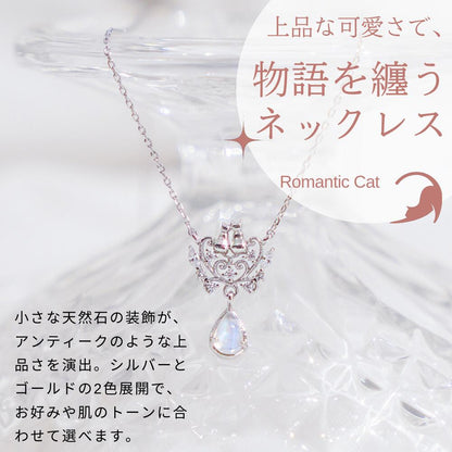 透明なガラスに映えるシルバーの猫モチーフネックレスのアップ。「上品な可愛さで、物語を纏うネックレス Romantic Cat」小さな天然石がアンティークな上品さを演出、シルバーとゴールドの2色展開とコピー。