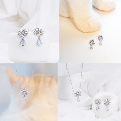 白い台座に置かれたシルバーのピアス、猫の足元に並べたピアス、猫の毛にピントを外して手前にネックレスを配置したカット、布の上でネックレスとピアスをセットで見せる構図など、シルバーカラーのディテールカット4枚組