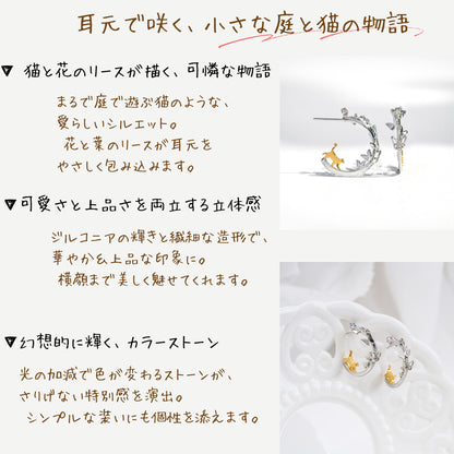 「耳元で咲く、小さな庭と猫の物語」の見出し。猫と花のリースが描く立体的なシルエット、ジルコニアの輝き、光で色が変わるストーンという3つの特徴を文章とピアス写真で紹介。