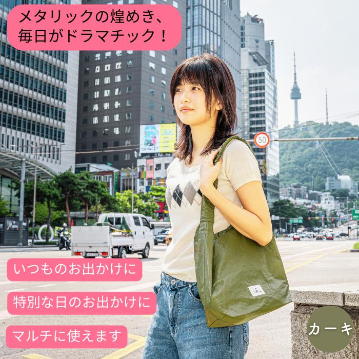「メタリックの煌めき、毎日がドラマチック！」の見出し。ソウルの街中でカーキ色のバッグを肩掛けする女性、いつものお出かけにも特別な日にも使えると訴求