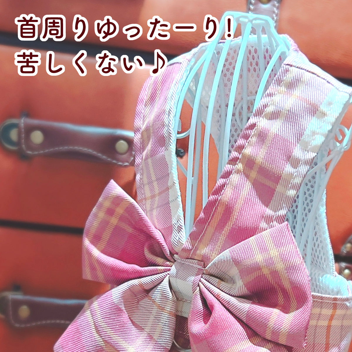 ピンク系チェック柄のワンピースハーネスの首回りメッシュ部分クローズアップ。「首周りゆったーり！苦しくない♪」の文字で締め付けの少なさを紹介